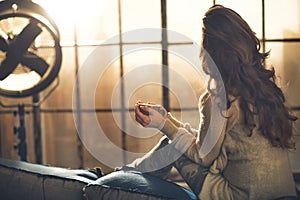 Woman enjoying cup of beverage in loft apartment