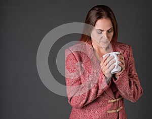 Woman enjoying a cup of coffee in a tacky business suit