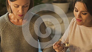 Woman enjoying dessert, laughing at friend eating salad, junk food vs healthcare