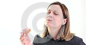 Woman enjoying eating sweet tasty donut on white background 4k movie slow motion