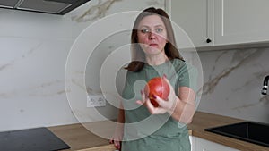 Woman Enjoying Fresh Red Apple in Modern Kitchen During Daytime