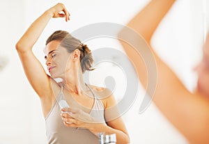 Woman enjoying freshness after applying roller deodorant