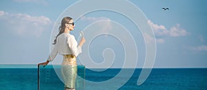 Woman enjoying glass of champagne at the sea