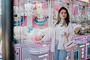 Woman enjoying her time at an arcade with a cup of ice cream
