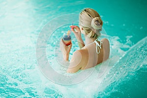 Woman enjoying hydrotherapy and cocktail