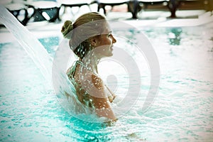 Woman enjoying hydrotherapy in spa pool