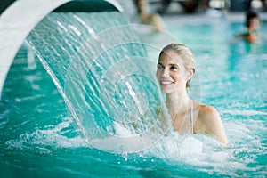 Woman enjoying hydrotherapy in spa pool photo