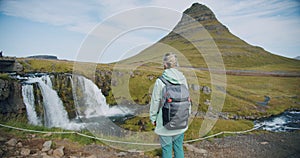 Woman enjoying Kirkjufellsfoss and Kirkjufell in northern Iceland