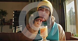 Woman enjoying a latte in a sunlit cafe. Relaxation and leisure concept. Design for lifestyle blog, coffee shop