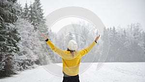 Woman enjoying life standing in white snowy winter nature