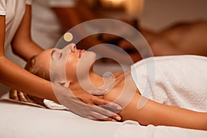 Woman Enjoying Massage During Couples Beauty Treatment Lying At Spa