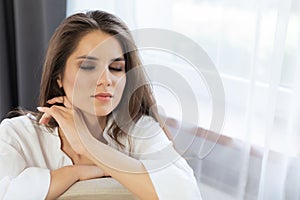 Woman enjoying morning awakening in a soft snow-white bed