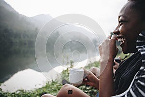 Woman enjoying morning coffee by a river