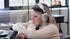 Woman Enjoying Music At Home On Sofa