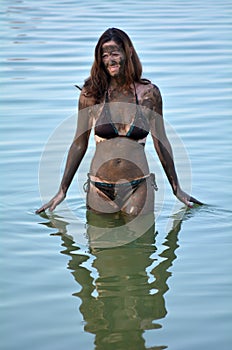 Woman enjoying the natural mineral mud sourced from the Dead Sea