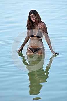 Woman enjoying the natural mineral mud sourced from the Dead Sea