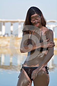 Woman enjoying the natural mineral mud sourced from the Dead Sea