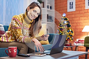 Woman enjoying online Christmas shopping at home