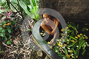 Woman enjoying in outdoor tropical spa bath tub