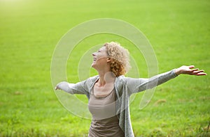 Woman enjoying the outdoors with arms spread open
