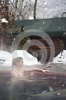 Woman enjoying the panoramic view from the pool in the alps photo