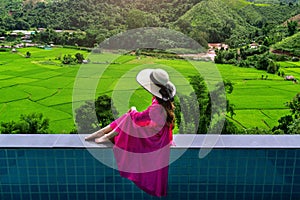Woman enjoying rice terrace viewpoint and green forest in Nan, Thailand