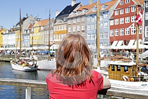 Woman enjoying the scenic view of Nyhavn pier, Copenhagen, Denmark