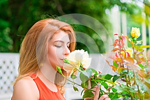 Woman enjoying the scent of blooming roses
