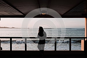 Woman enjoying the sea from a viewpoint at sunset photo