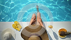 Woman enjoying summer day at beach resort hotel, touching smooth depilated legs