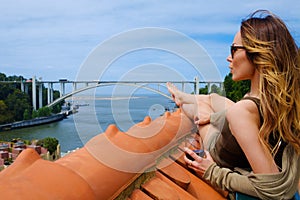 Woman enjoying sunbath on the rooftop on river bridge background.