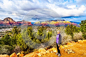 Woman enjoying the sunset over Thunder Mountain and other red rock mountains surrounding the town of Sedona, Arizona, USA