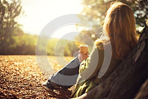 Woman enjoying takeaway coffee cup on sunny cold fall day photo