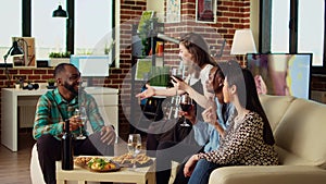 Woman enjoying talking with mates, having fun together, eating snacks in modern living room