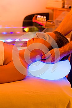 Woman enjoying therapy in spa with color therapy