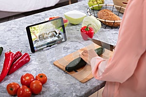 Woman Enjoying The Video While Cutting Cucumber