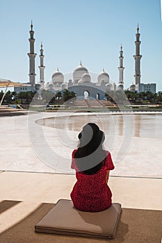 Woman enjoying view of Sheikh Zayed Grand Mosque in Abu Dhabi, United Arab Emirates on a sunny day