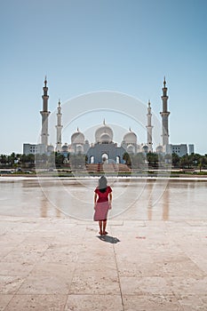 Woman enjoying view of Sheikh Zayed Grand Mosque in Abu Dhabi, United Arab Emirates on a sunny day