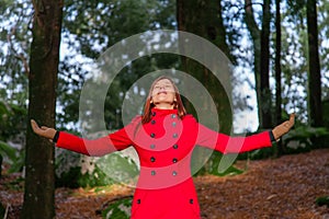 Woman enjoying the warmth of the winter sunlight on a forest