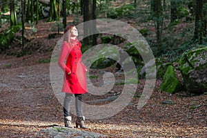 Woman enjoying the warmth of the winter sunlight on a forest