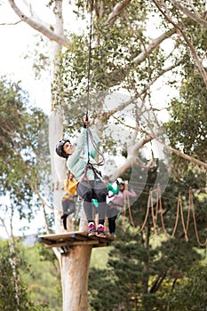 Woman enjoying zip line adventure in park