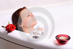 Woman enjoys the bath-foam in the bathtub.