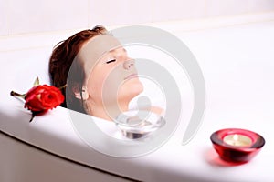 Woman enjoys the bath-foam in the bathtub.