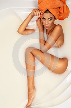 Woman enjoys a bath with milk