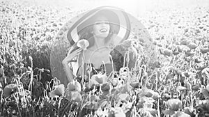 Woman enjoys summer rest. flower bouquet at smiling girl in retro hat, poppy field