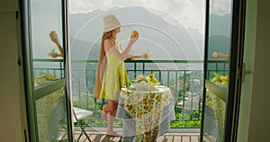 A woman enjoys a sunny balcony view while eating fruity ice cream lemon sorbet in Italy.