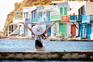 Woman enjoys the view to the colorful fishing village of Klima, Milos