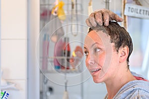 Woman ensuring that hair dye has reached the roots