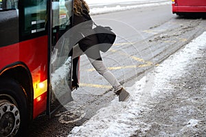 Woman entering bus in winter