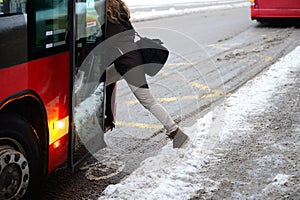 Woman entering bus in winter photo